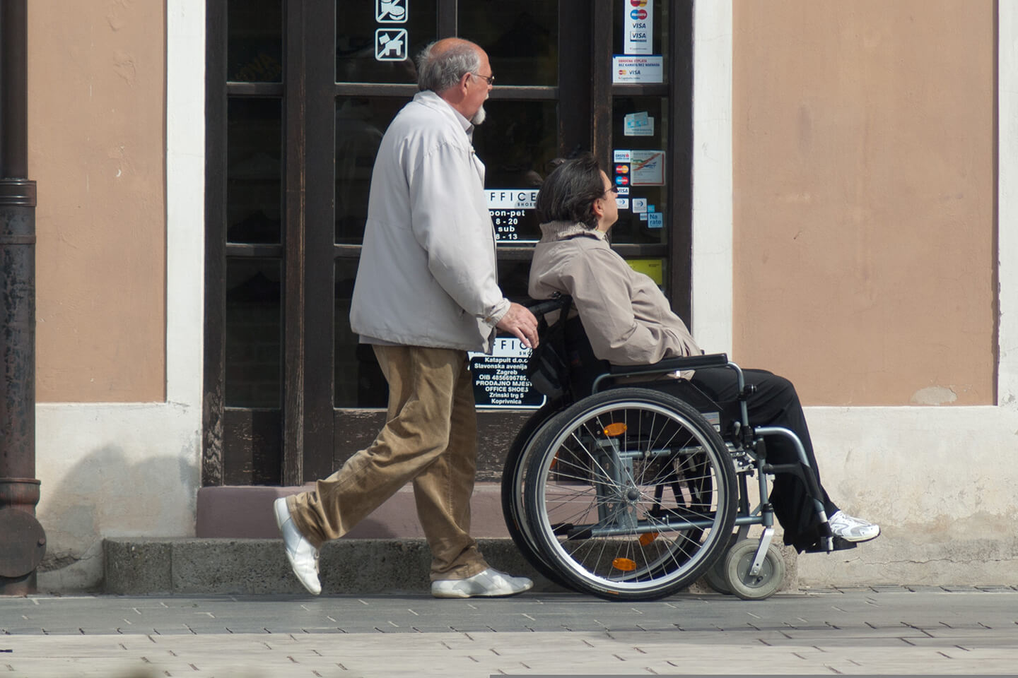 Man pushing another man in a wheelchair